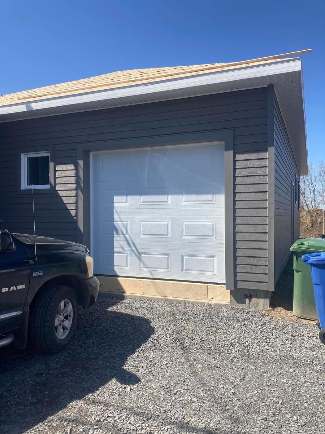 Porte de garage blanche sur un garage détaché