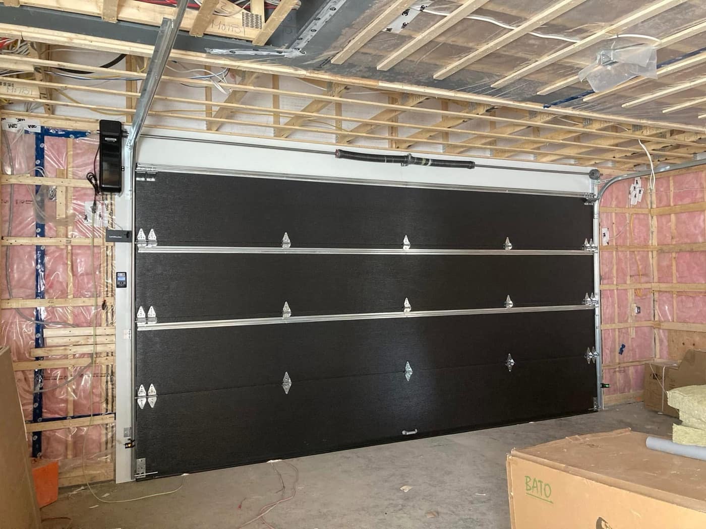 Porte de garage noire vue de l'intérieur, rails posés